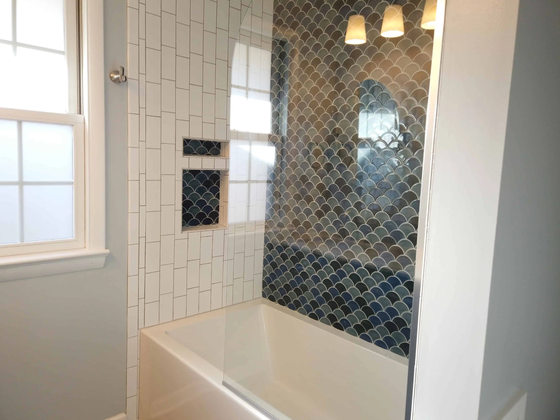 Tub surround with blue fish-scale tile and white subway accents