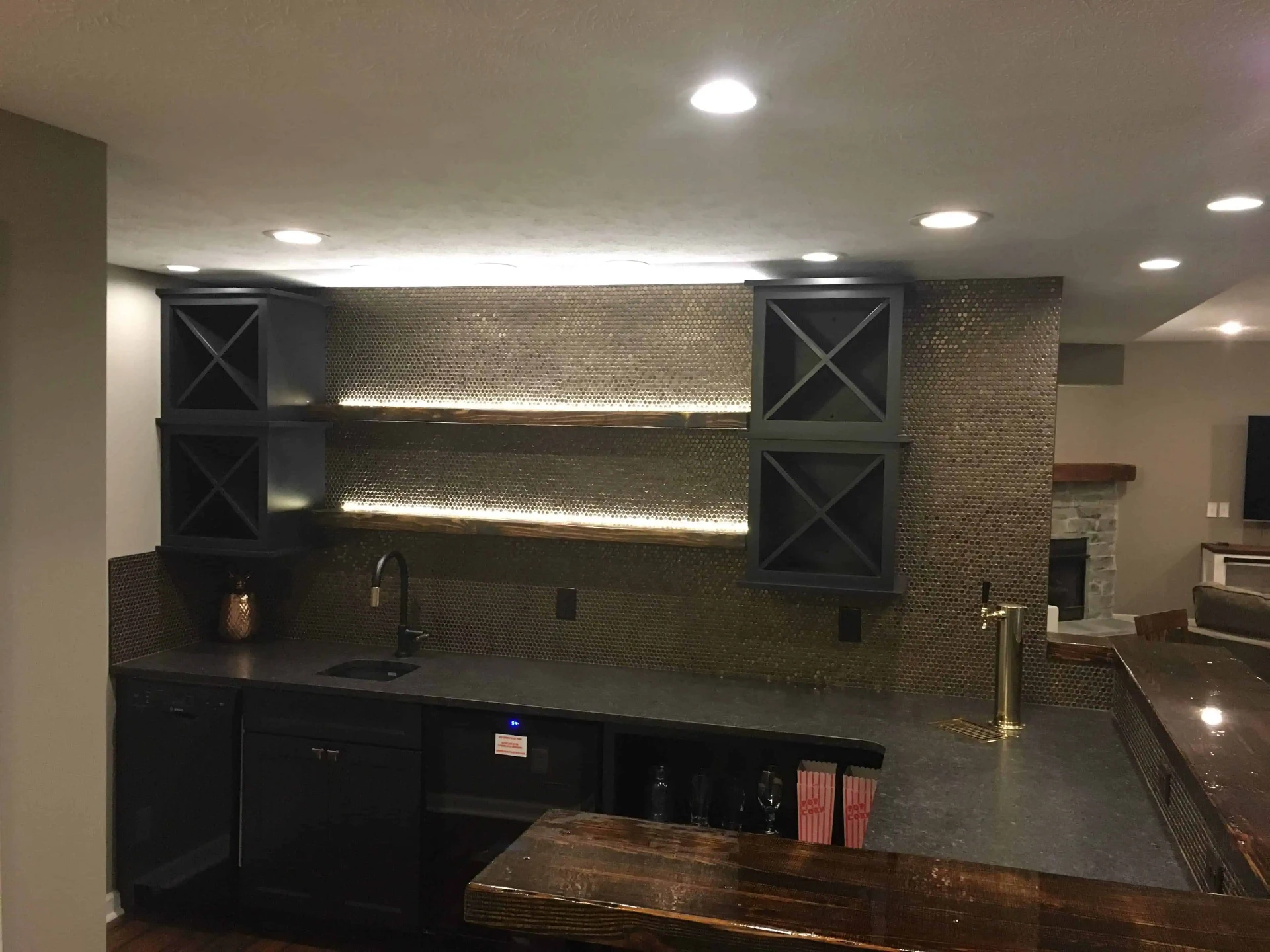 Basement wet bar with penny tile backsplash and lit floating shelves